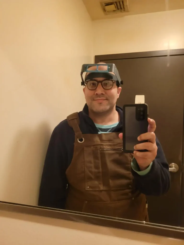 a man taking a picture in mirror for showing best woodworking aprons.